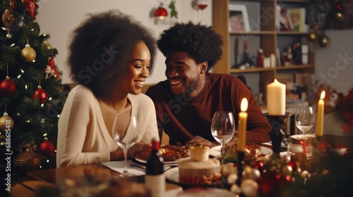Young African American couple drinking wine during dinner while celebrating Christmas at home. man and woman celebrating christmas