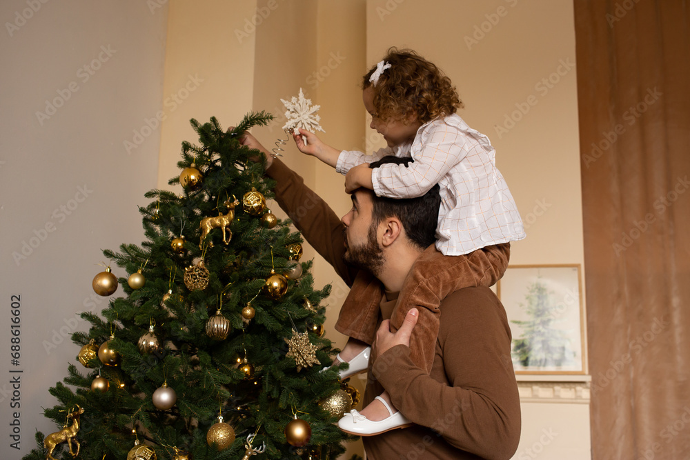happy father and little daughter on his head decorating Christmas tree happy father and little daughter on his head decorating Christmas tree