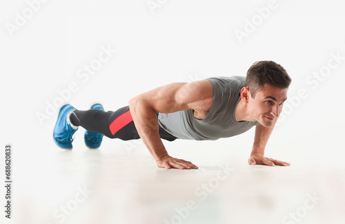 Fitness man wringing from the floor demonstrates good physical exercises isolated on white background healthy lifestyle for many people exercising their own weight for losing for every day push up.