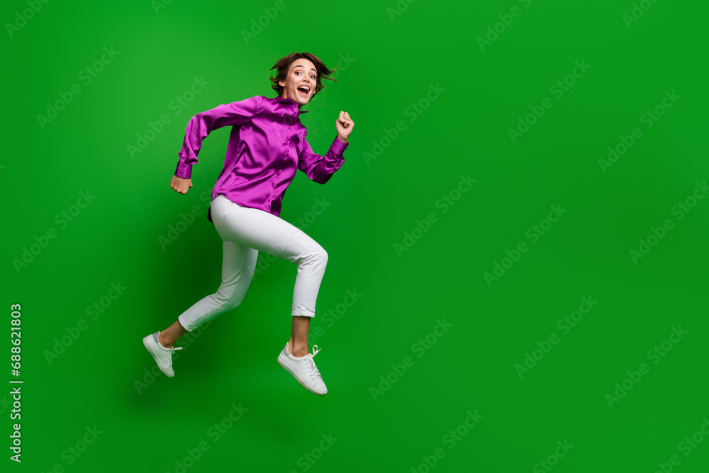Full body profile portrait of overjoyed active nice lady jump run empty space isolated on green color background Full body profile portrait of overjoyed active nice lady jump run empty space isolated on green color background