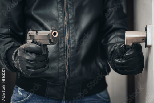 an armed criminal with a dhrt pistol enters the premises. Attempted robbery. Crime concept. bank robbery. self-defense with firearms. the man hides the gun behind his back.
