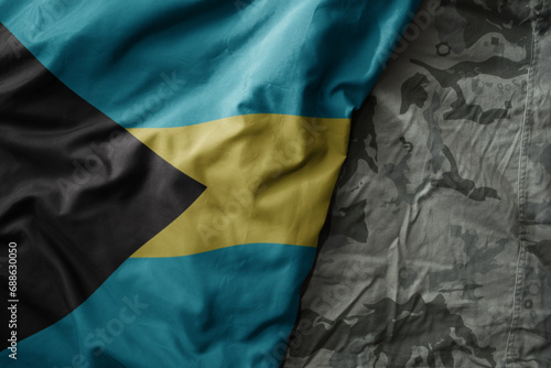 waving flag of bahamas on the old khaki texture background. military concept.
