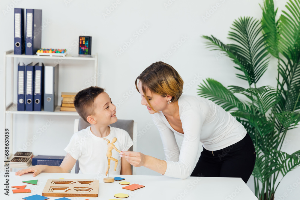 Fototapeta premium A boy with a teacher learns develops in the psychologist's office