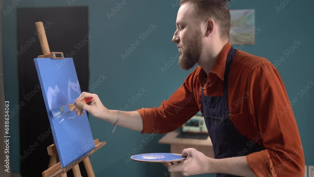 Painter man in home workshop painting picture on canvas with paints, enjoy creative hobby. Talent and art-class