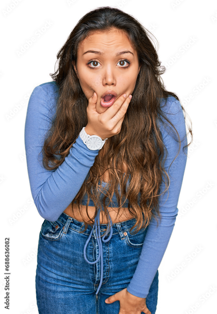 Young hispanic girl wearing casual clothes looking fascinated with disbelief, surprise and amazed expression with hands on chin Young hispanic girl wearing casual clothes looking fascinated with disbelief, surprise and amazed expression with hands on chin
