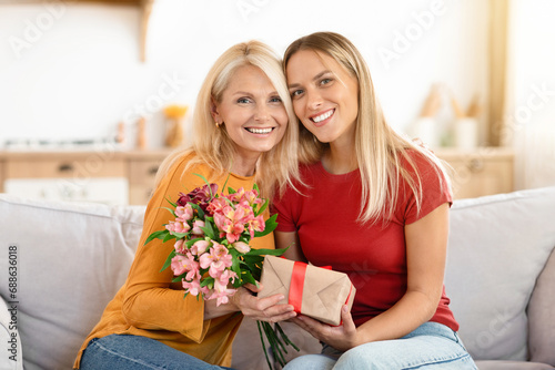 Loving young adult woman congratulate elderly mom with Mothers Day