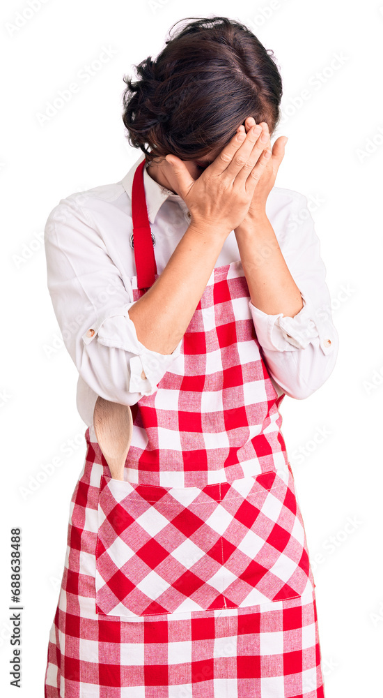 Beautiful young woman with short hair wearing professional cook apron with sad expression covering face with hands while crying. depression concept. Beautiful young woman with short hair wearing professional cook apron with sad expression covering face with hands while crying. depression concept.
