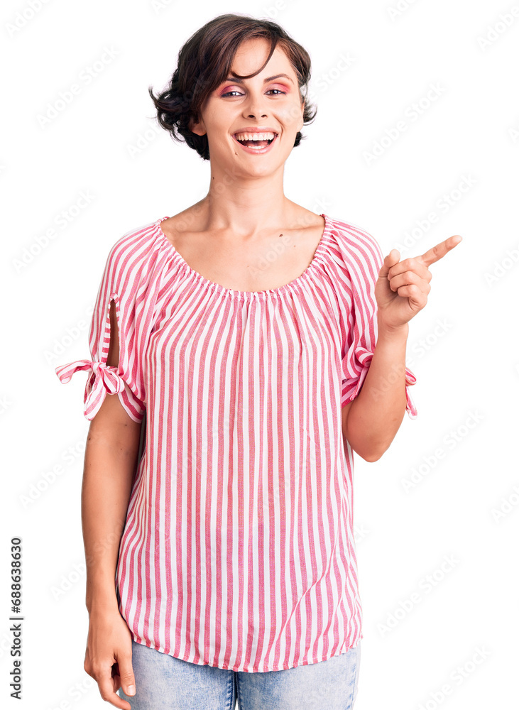 Beautiful young woman with short hair wearing casual summer clothes with a big smile on face, pointing with hand finger to the side looking at the camera. Beautiful young woman with short hair wearing casual summer clothes with a big smile on face, pointing with hand finger to the side looking at the camera.