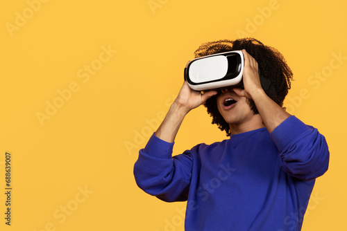 Young african american guy in casual using VR glasses