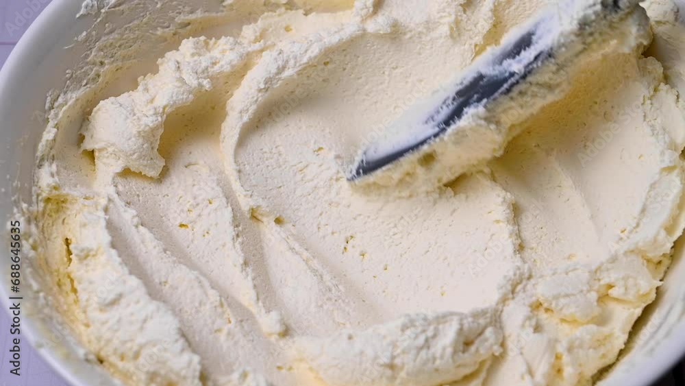 Stirring whipped cream in a bowl, cooking white cream for cake Stirring whipped cream in a bowl, cooking white cream for cake