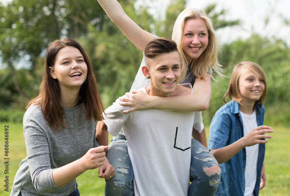 Teenagers running through green lawn in summer in park Teenagers running through green lawn in summer in park