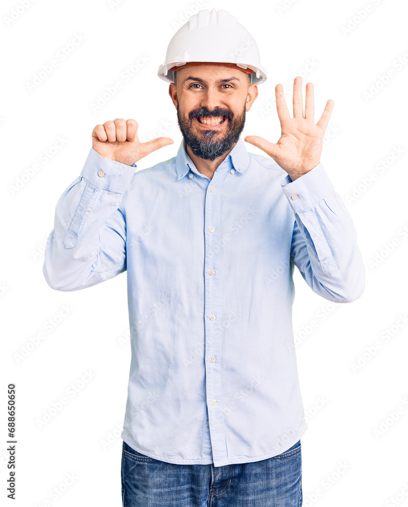 Young handsome man wearing architect hardhat showing and pointing up with fingers number six while smiling confident and happy.