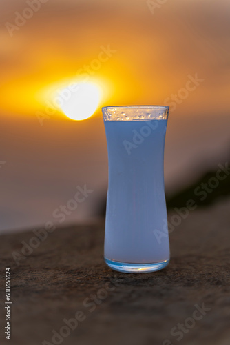 Glass of raki the famous drink of the Turkey against the sunset view photo