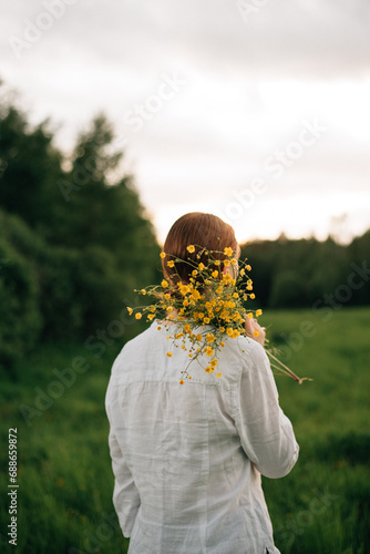 red-haired girl with a bouquet of yellow buttercups