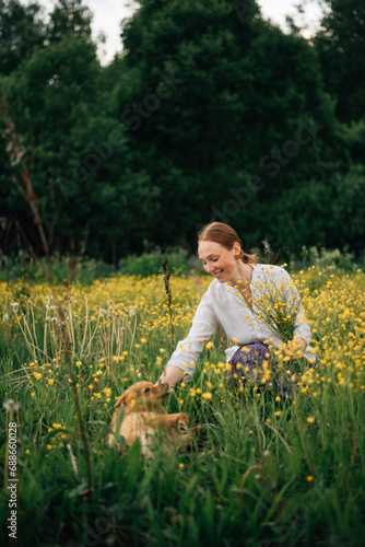 red-haired girl with a red fluffy dog in flowers
