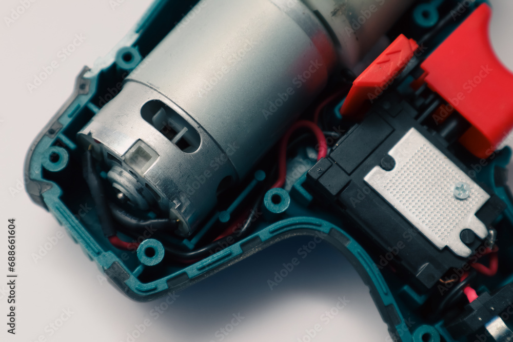 Repair of a Battery screwdriver with a brushless motor. Disassembled screwdriver on a white background.
