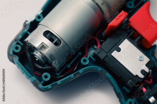 Repair of a Battery screwdriver with a brushless motor. Disassembled screwdriver on a white background.