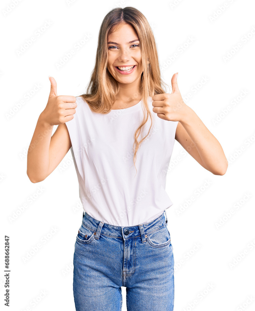 Beautiful caucasian woman with blonde hair wearing casual white tshirt success sign doing positive gesture with hand, thumbs up smiling and happy. cheerful expression and winner gesture. Beautiful caucasian woman with blonde hair wearing casual white tshirt success sign doing positive gesture with hand, thumbs up smiling and happy. cheerful expression and winner gesture.