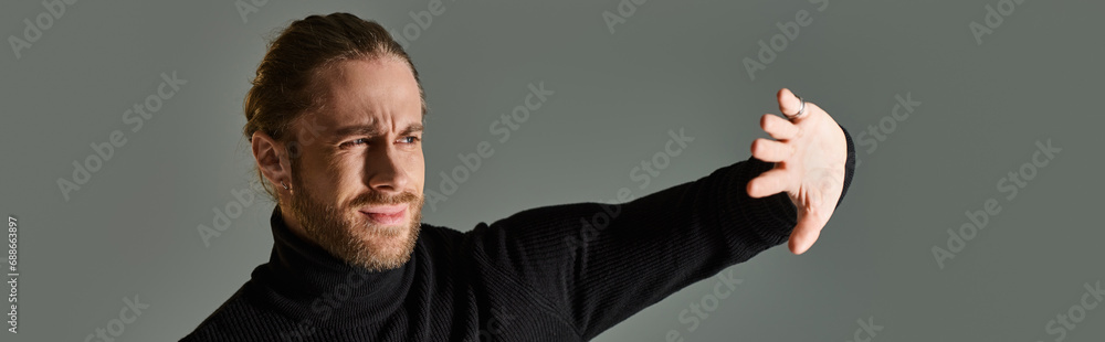 portrait of displeased man in turtleneck sweater posing with hands near face on grey, banner portrait of displeased man in turtleneck sweater posing with hands near face on grey, banner