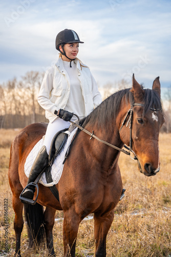 Beautiful blond professional female jockey riding a horse © dtatiana