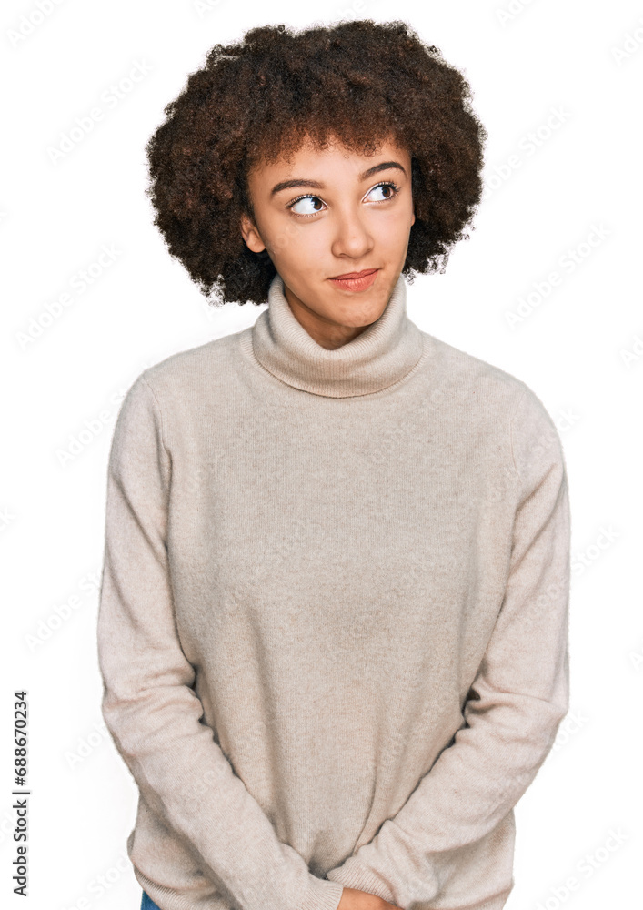 Young hispanic girl wearing wool winter sweater smiling looking to the side and staring away thinking. Young hispanic girl wearing wool winter sweater smiling looking to the side and staring away thinking.
