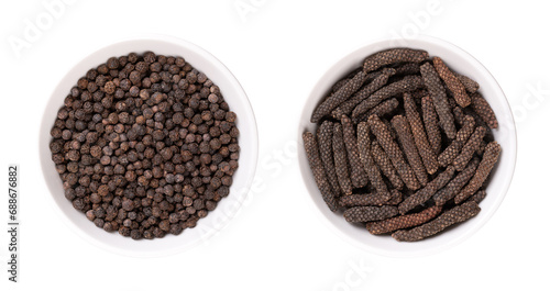 Dried black peppercorns and long pepper catkins, in white bowls. Berries of Piper nigrum, and fruits of Piper longum, sometimes called pippali. Used as spice and seasoning, both with similar taste.