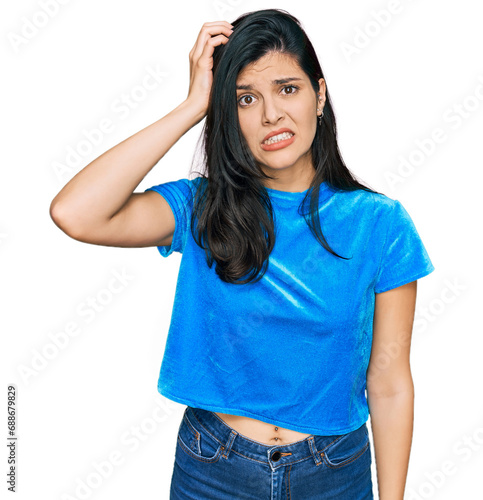 Young hispanic woman wearing casual clothes confuse and wonder about question. uncertain with doubt, thinking with hand on head. pensive concept.