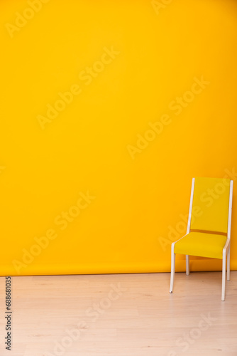 One yellow chair in orange wall interior