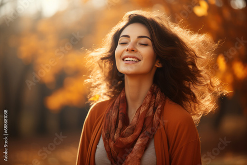 A brunette woman breathes calmly looking up enjoying autumn air