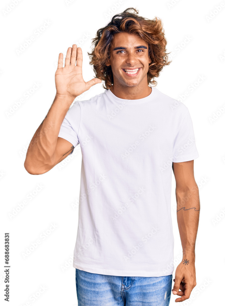 Young hispanic man wearing casual white tshirt waiving saying hello happy and smiling, friendly welcome gesture Young hispanic man wearing casual white tshirt waiving saying hello happy and smiling, friendly welcome gesture