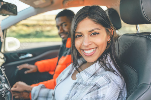 Beautiful happy young loving couple holding hands and smiling while sitting in their first car. Buy your first car concept toned image photo