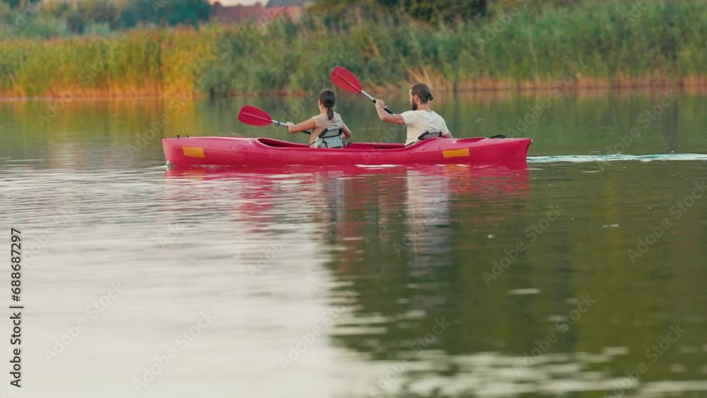 Back view of Caucasian couple spending time together romantically. In free time learning new type of sport. Boosting their learning curve. Trying to hold balance and paddle correctly. Back view of Caucasian couple spending time together romantically. In free time learning new type of sport. Boosting their learning curve. Trying to hold balance and paddle correctly.