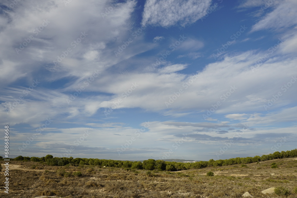  Horizon and mountains in the distance. View of the lagoon in Spain. Blue sky and clouds.