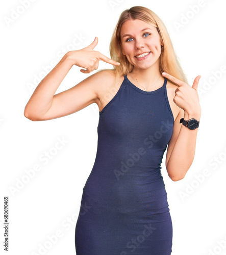 Young beautiful blonde woman wearing casual dress smiling cheerful showing and pointing with fingers teeth and mouth. dental health concept.