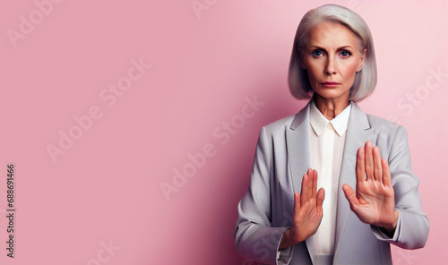 Portrait of an mature woman, showing a stop gesture, saying no, raise awareness photo
