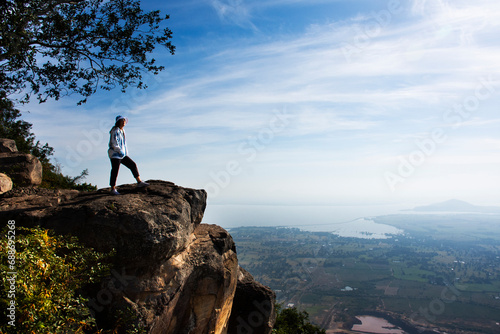 Travelers thai women people travel visit and take photo on ridge stone of cliffs Khao Phraya Doen Thong viewpoint with aerial view landscape rice field at Phatthana Nikhom village in Lopburi, Thailand