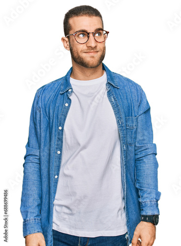 Young caucasian man wearing casual clothes smiling looking to the side and staring away thinking.