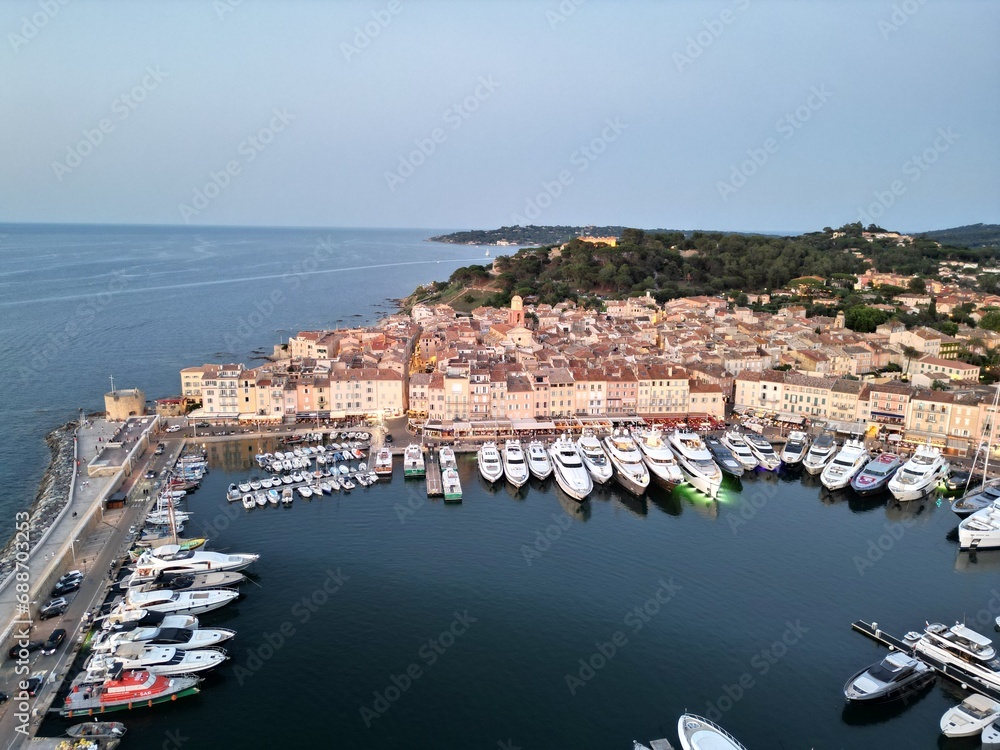 Row of Super yachts moored Saint Tropez port France evening drone aerial