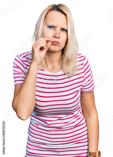 Young caucasian woman wearing casual clothes mouth and lips shut as zip with fingers. secret and silent, taboo talking