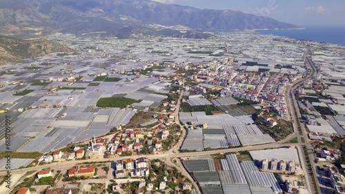 Demra, Turkey. Modern greenhouse farms for year-round cultivation of vegetables. Top view from on gray roofs of modern block greenhouses on sunny day. The concept of growing vegetables in greenhouses photo