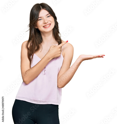 Young beautiful caucasian girl wearing casual clothes amazed and smiling to the camera while presenting with hand and pointing with finger.