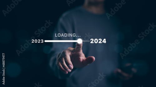 Man hand touching loading bar for countdown to 2024. In progress loading year 2023 to 2024, Planning and challenge business strategy in new year, Countdown merry Christmas and Happy New Year, Startup, photo