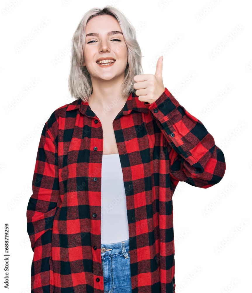 Young blonde girl wearing casual clothes smiling happy and positive, thumb up doing excellent and approval sign Young blonde girl wearing casual clothes smiling happy and positive, thumb up doing excellent and approval sign