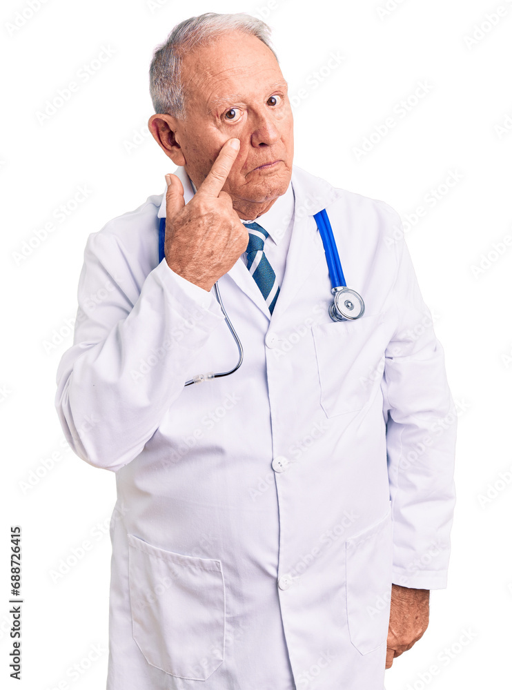 Senior handsome grey-haired man wearing doctor coat and stethoscope pointing to the eye watching you gesture, suspicious expression Senior handsome grey-haired man wearing doctor coat and stethoscope pointing to the eye watching you gesture, suspicious expression