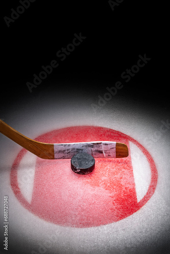 Canvas Print Looking down on hockey stick with a puck sitting on the Face-Off circle in the spot light