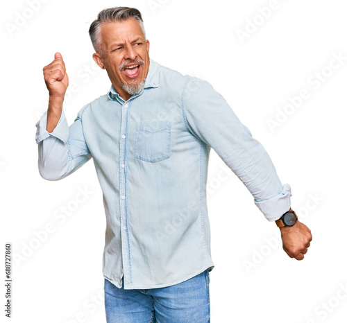 Middle age grey-haired man wearing casual clothes dancing happy and cheerful, smiling moving casual and confident listening to music