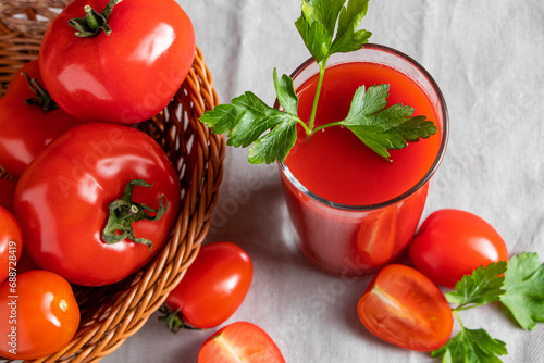 Fresh tomato juice on wooden rustic background. Organic vegetable drink with parsley. © Sanda