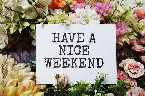 Have a nice Weekend text message on paper card with beautiful flowers decoration photo