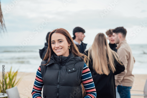 Happy young woman with friends standing on beach