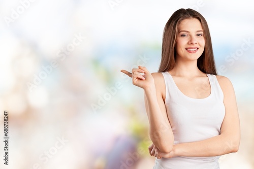 Young beautiful woman pointing to empty space